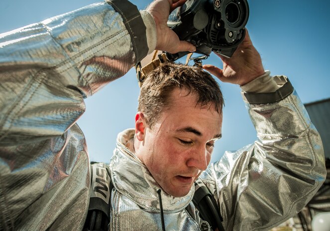 Airman 1st Class Michael Shonebarger, 628th Civil Engineer Squadron firefighter, removes his gas mask after an aircraft, live-fire training exercise March 29, 2013, at Joint Base Charleston – Air Base, S.C. The base performs quarterly aircraft, live-fire training for firefighters and crew chiefs to maintain their qualifications. (U.S. Air Force photo/ Senior Airman Dennis Sloan)