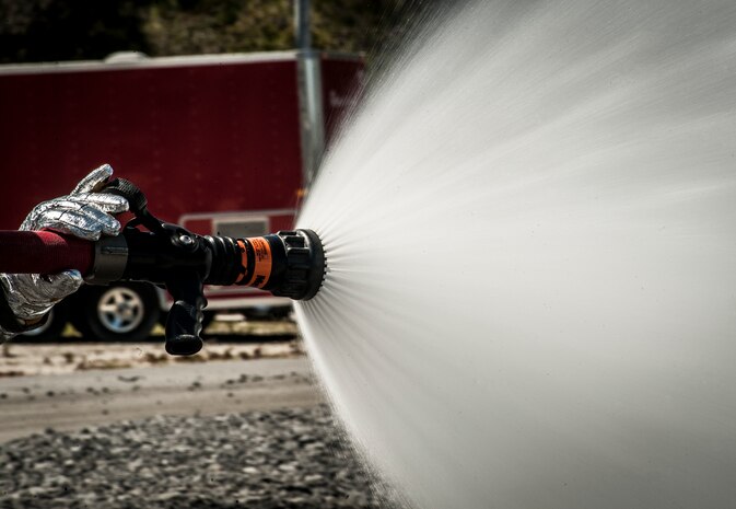 A 628th Civil Engineer Squadron firefighter sprays water on a fire during an aircraft, live-fire training exercise March 29, 2013, at Joint Base Charleston – Air Base, S.C. The base performs quarterly aircraft, live-fire training for firefighters and crew chiefs to maintain their qualifications. (U.S. Air Force photo/ Senior Airman Dennis Sloan)
