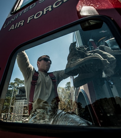 Staff Sgt. Travis Cumpston, 628th Civil Engineer Squadron crew chief, jumps into a Striker 3000 fire truck during an aircraft, live-fire training exercise March 29, 2013, at Joint Base Charleston – Air Base, S.C. The base performs quarterly aircraft live-fire training for firefighters and crew chiefs to maintain their qualifications. (U.S. Air Force photo/ Senior Airman Dennis Sloan)