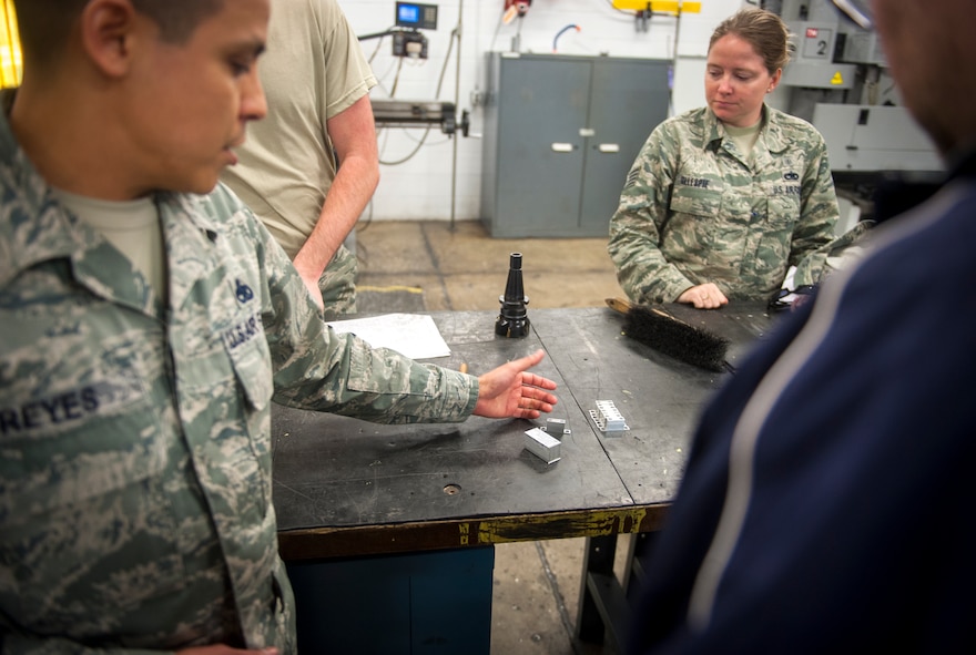 U.S. Air Force Master Sgt. Felipe Reyes, 23d Equipment Maintenance Squadron NCO in charge of aircraft metals technology, shows parts to bioenvironmental Airmen during a health-risk assessment at Moody Air Force Base, Ga., March 25, 2013. The bioenvironmental Airmen inspected the metals technology shop and spoke to Reyes about possible hazards on the job. (U.S. Air Force photo by Senior Airman Jarrod Grammel/Released)
