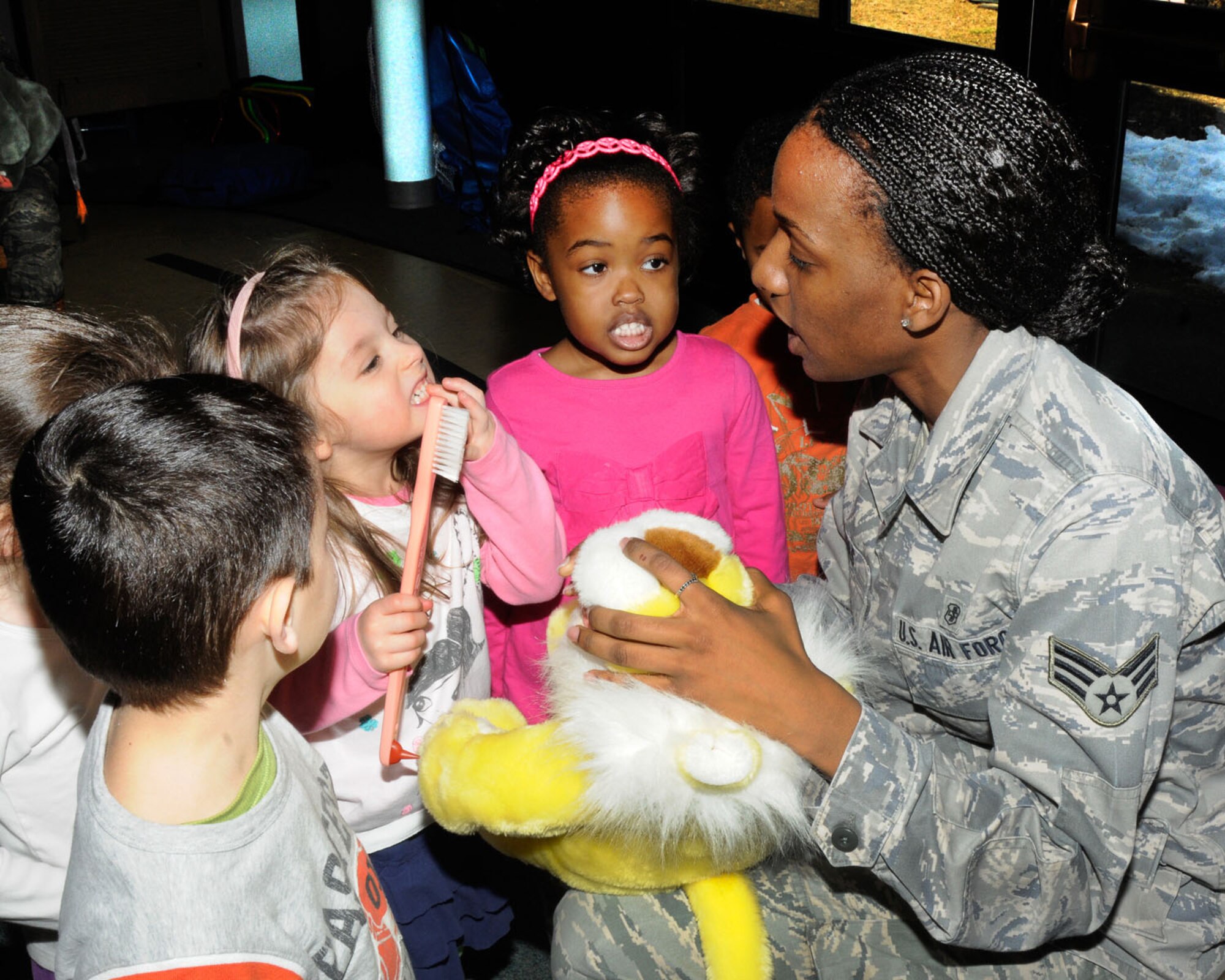 HANSCOM AIR FORCE BASE, Mass. – Senior Airman Lakendria Thomas, a dental technician, uses props and stuffed animals to teach children at the Child Development Center about taking care of their teeth March 26. The 66th Medical Squadron Dental Flight visits school aged children each year to talk to them about proper oral hygiene and nutrition. (U.S. Air Force photo by Linda LaBonte Britt)