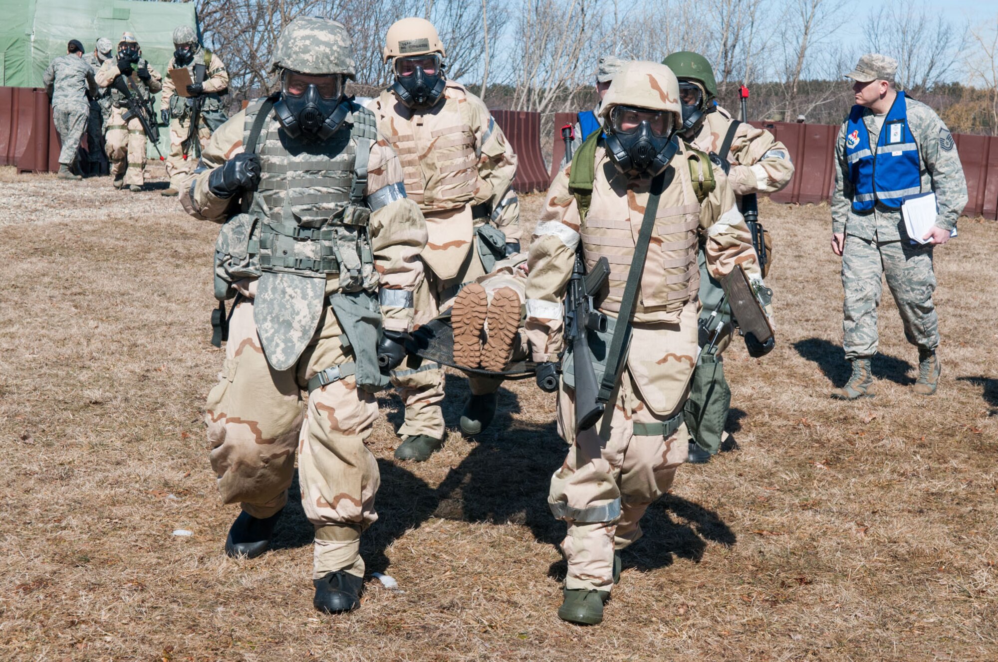 HANSCOM AIR FORCE BASE, Mass. - Airmen perform a litter carry during a simulated chemical attack during the base readiness exercise at Camp Patriot March 27. The combat scenarios practiced during BREs are designed to help prepare personnel for deployed environments. (U.S. Air Force photo by Rick Berry)