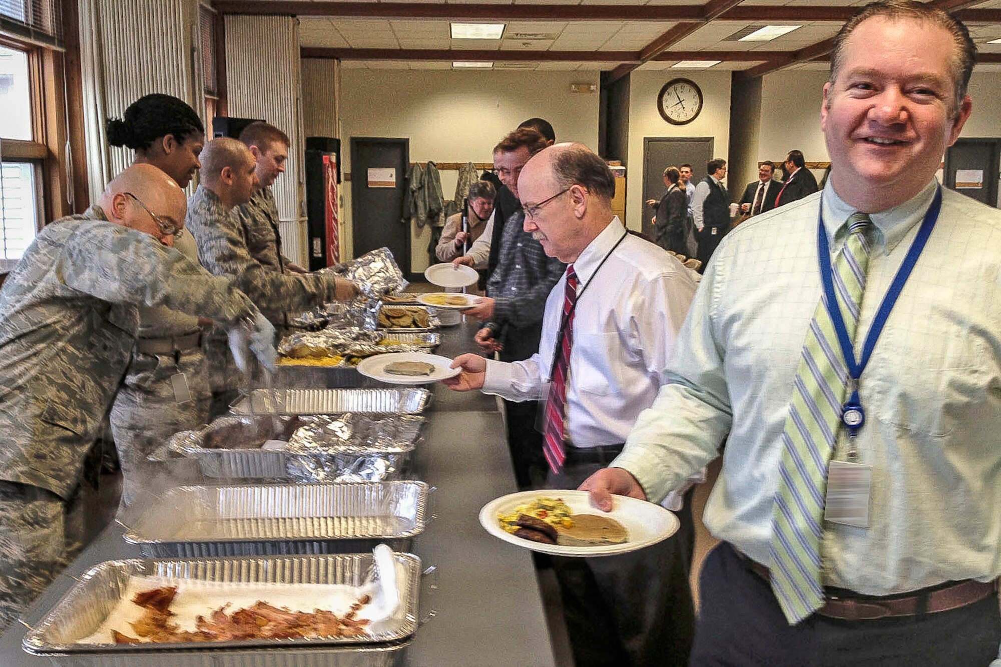 HANSCOM AIR FORCE BASE, Mass. - Brian Murphy (right), a contract specialist, and other Contracting Directorate civilian employees enjoy breakfast provided by PK/ PZ military members at the base chapel March 28. The military members came up with the idea of a Civilian Appreciation Breakfast to show gratitude to civilians for their training, picking up the slack during military deployments and overall encouragement for military contracting professionals. (Courtesy photo) 