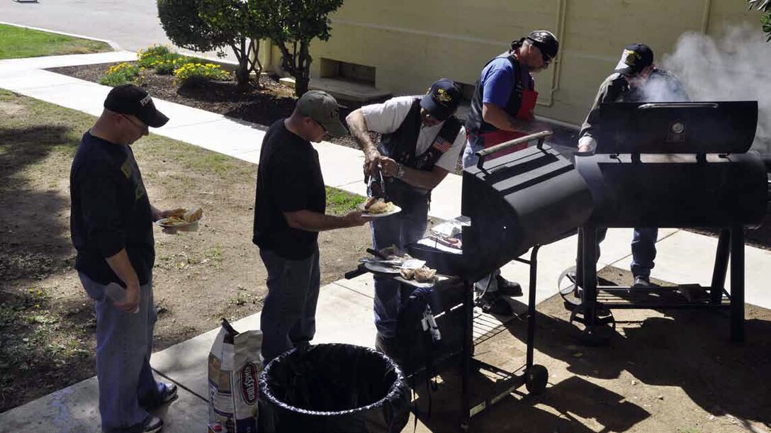 Members of the 4th Air Force closed out their day of spring cleaning with hotdogs and hamburgers, courtesy of volunteers from American Legion Riders Alliance, Perris Post 595 and San Jacinto Post 848, March 15; from center to right, Joe Ondarza, JR  “Tinman” Tofte and Dave Evans. (U.S. Air Force photo by Darnell Gardner)