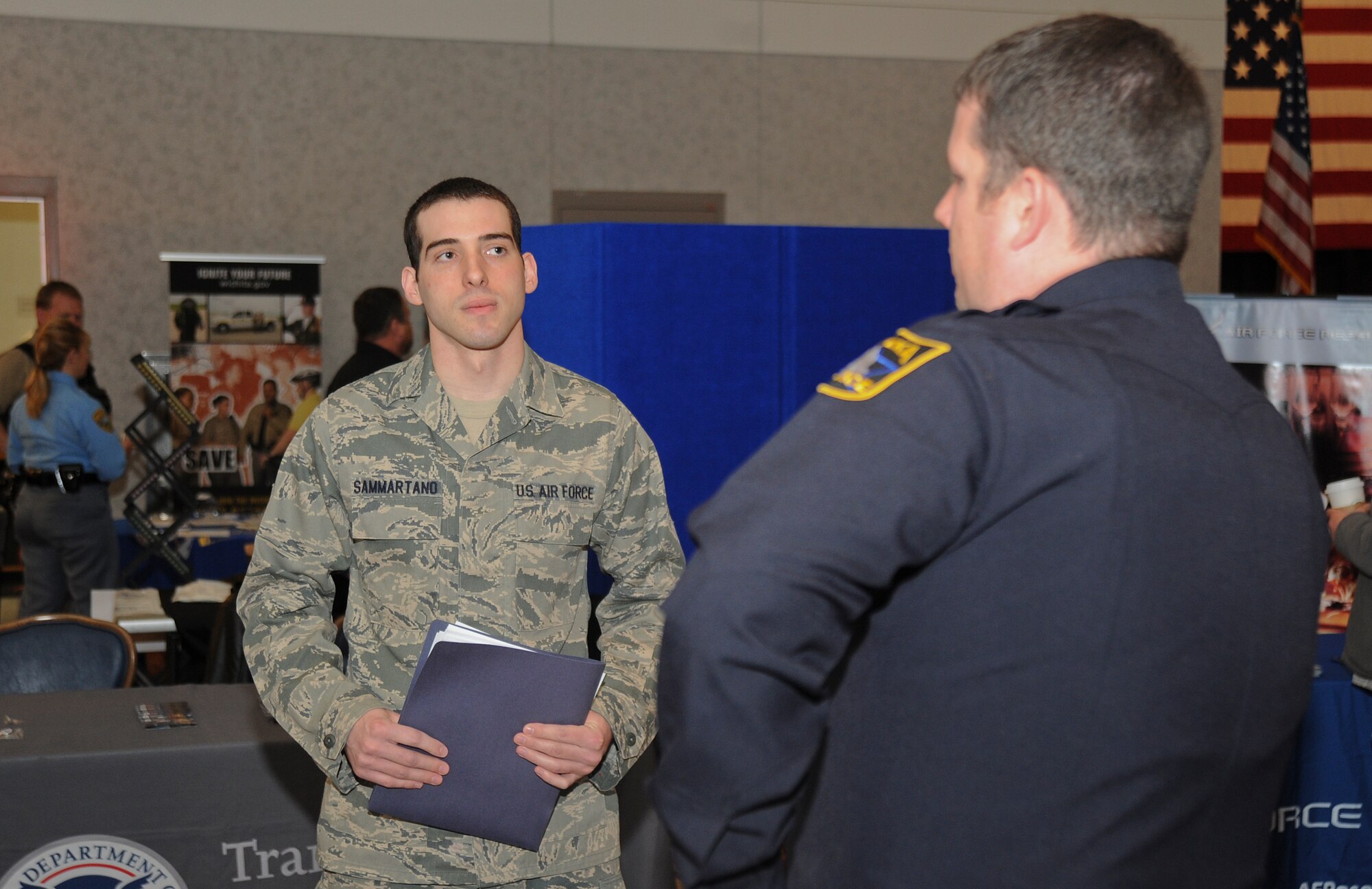 Senior Airman Craig Sammartano, 22nd Medical Support Squadron laboratory journeyman, speaks with a law enforcement officer during McConnell’s 2013 job fair April 3, 2013, McConnell Air Force Base, Kan. Despite Sammartano’s experience in the medical field, he is seeking a career in law enforcement after he separates from the U.S. Air Force. (U.S. Air Force photo/Airman 1st Class Jose L. Leon)