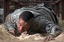 A Soldier attending the officer leadership course, low crawls through the sand at the obstacle course March 7, at Joint Base San Antonio-Camp Bullis (U.S. Air Force photo by Benjamin Faske) (released)