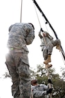 A soldier attending the officer leadership course, successfully scales the rope climb on March 7, at Joint Base San Antonio-Camp Bullis (U.S. Air Force photo by Benjamin Faske) (released)