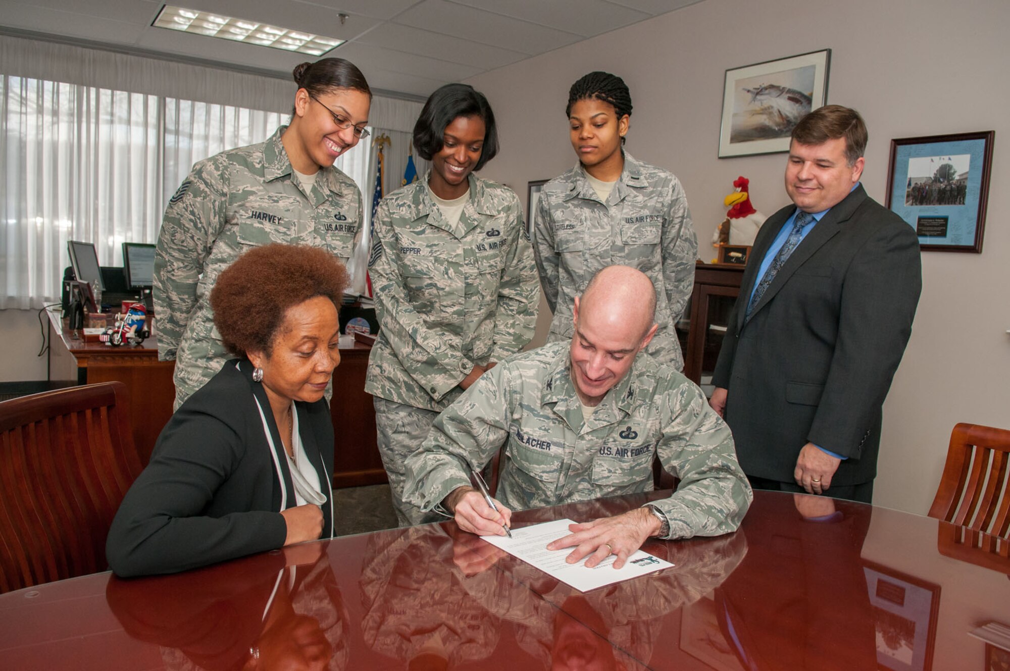 HANSCOM AIR FORCE BASE, Mass. – Col. Lester A. Weilacher, 66th Air Base Group commander, signs a proclamation in his office April 1 declaring April as Sexual Assault Awareness Month. Surrounding Weilacher are members of the SAAM committee and Tom Fredericks (right), 66th Air Base Group deputy director. (U.S. Air Force photo by Rick Berry) 