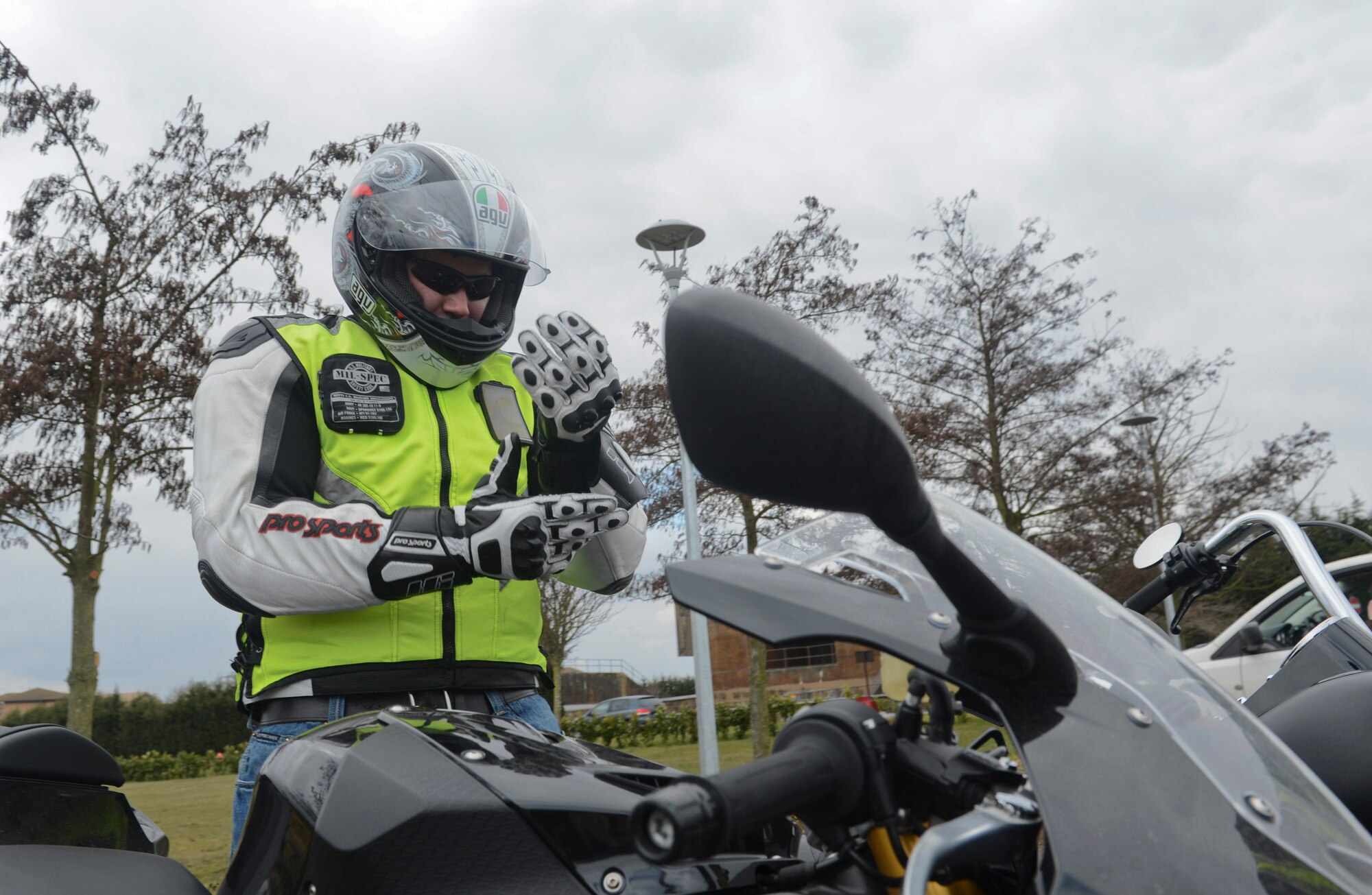 ROYAL AIR FORCE LAKENHEATH, England - Airman 1st Class Douglas Lust, a motorcycle riding instructor and 48th Logistics Readiness Squadron vehicle maintenance journeyman, puts on gloves before a "poker run" March 29, 2013. The "poker run" group ride was sponsored by Chapter 86 of the Green Knights Military Motorcycle Club. The annual pre-season motorcycle briefs took place at RAF Lakenheath March 29, 2013 and RAF Mildenhall April 1, 2013. (U.S. Air Force photo by Staff Sgt. Stephen Linch)