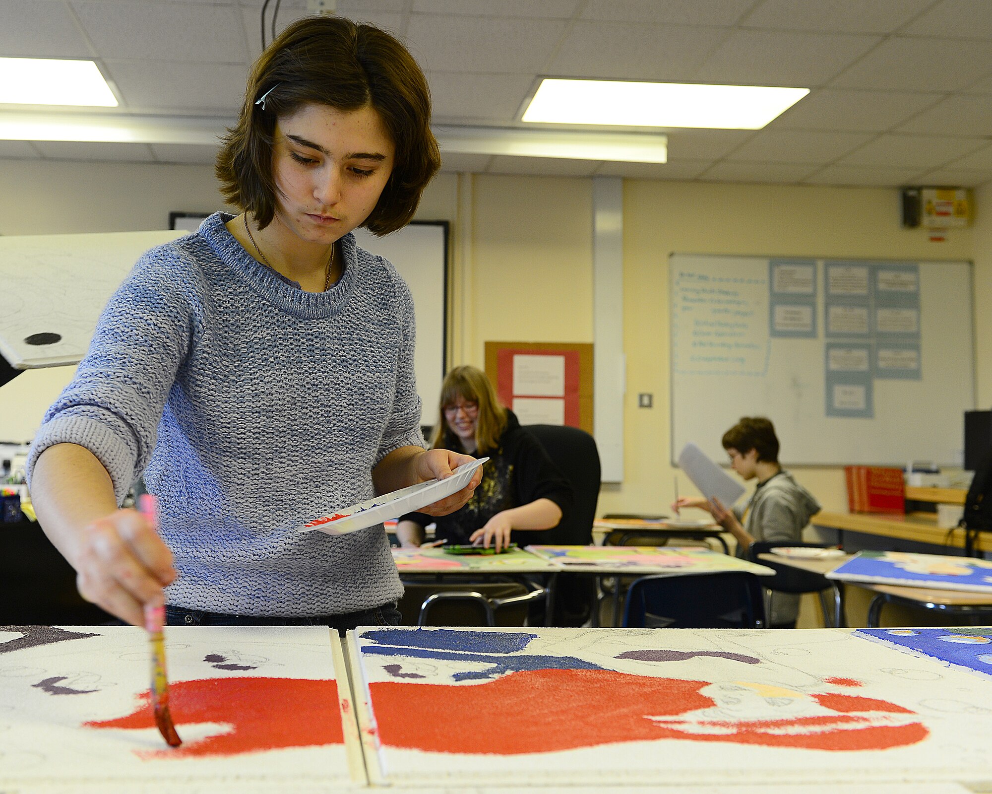 ROYAL AIR FORCE LAKENHEATH, England – Marrisa Peredo, daughter of Col. Dawn Peredo, 48th Medical Operations Squadron educational and developmental intervention services medical director, paints the Little Mermaid on hospital tiles, April 1, 2013. Lakenheath High School students volunteered to paint tiles for 12 pediatrics rooms; each room has a different theme. The tiles are scheduled to be completed by May. (U.S. Air Force photo by Staff Sgt. Stephanie Mancha)
