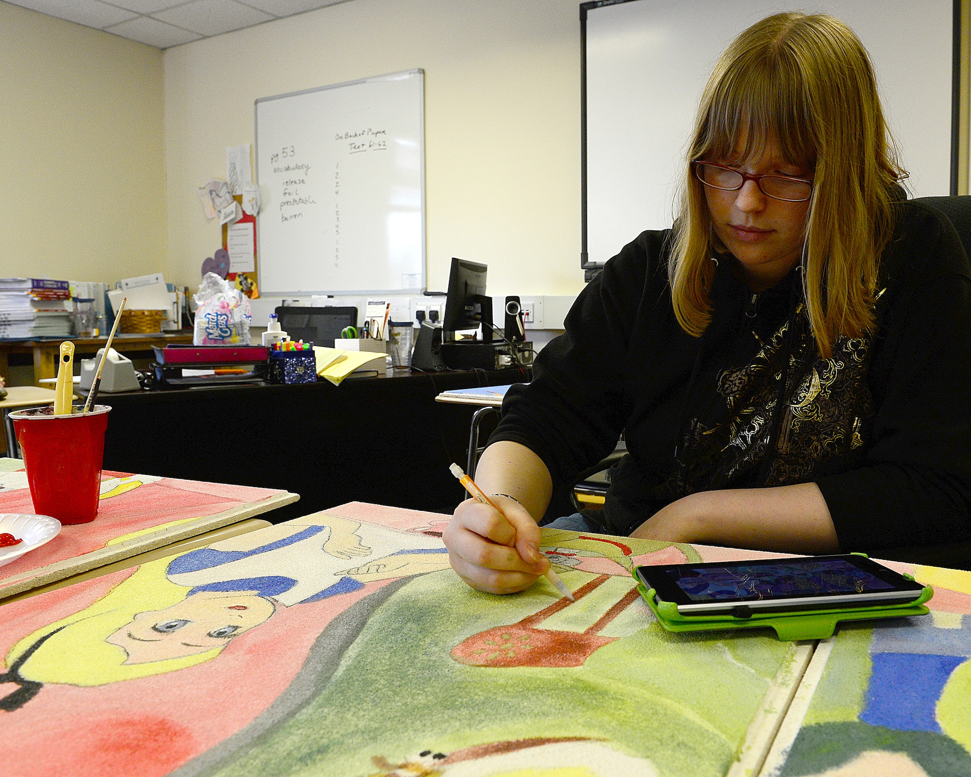 ROYAL AIR FORCE LAKENHEATH, England—Heather  Schepperle, daughter of Master Sgt. Shawn Schepperle, 48th Civil Engineer Squadron NCO in charge of quality assurance, uses a tablet to draw and paint Alice in Wonderland characters on to hospital tiles April 1, 2013. The tiles are scheduled to be completed by May and will be displayed in 12 pediatrics rooms. (U.S. Air Force photo by Staff Sgt. Stephanie Mancha)