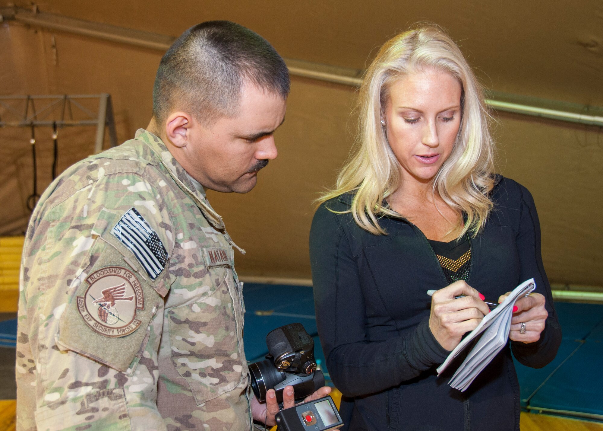 Senior Airman Nicholas Navarro, a transiting service member on his way home from Afghanistan, shares social media contact information with Beth Horn, also known as Venom from the American Gladiators, during a meet and greet session April 2, 2013, at Transit Center at Manas, Kyrgyzstan. Horn, along with Billy Blanks and three other American Gladiators, are on a six-stop tour of Southwest and Central Asia. (U.S. Air Force photo/Tech. Sgt. Rachel Martinez)