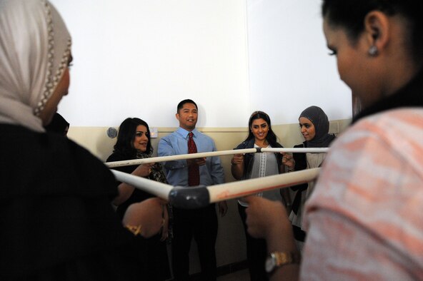 Capt. Carlos Bersabe, 386th Expeditionary Mission Support Group, breaks the ice with a team building exercise in which students worked together to lower the square to the floor with only one finger at a host nation university, Southwest Asia Apr 3, 2013. Capt. Bersabe was the first person selected under a newly formed U.S. Embassy and 386th Air Expeditionary Wing Public Affairs speakers program in which service members are permitted the opportunity to lecture at host nation universities. (U.S. Air Force photo by Senior Master Sgt. George Thompson)