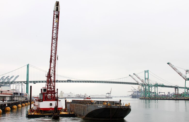 A crane lifts the last bucketfull of material from the Port of Los Angeles main channel April 3, marking the end of the Corps' 10-year project.  The dredging project removed 15 million cubic yards of material in total, deepening the channel to a depth of 53 feet that will allow passage of "post-Panamax" ships.