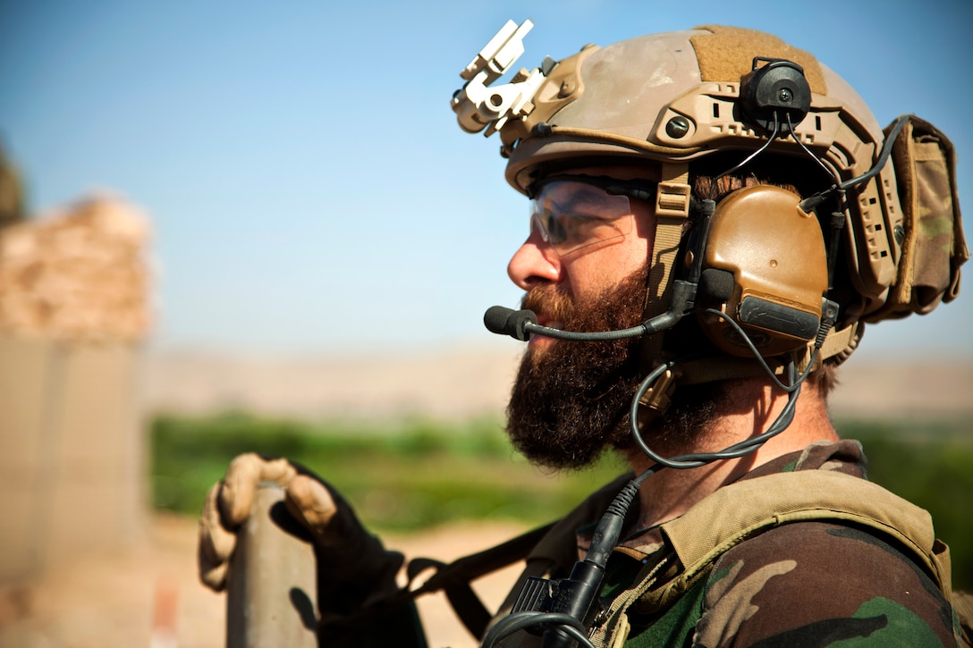 A U.S. Marine Corps Special Operations team member provides over watch security for Afghan national army special forces to help Afghan local police build a checkpoint in Helmand province, Afghanistan, April 3, 2013.