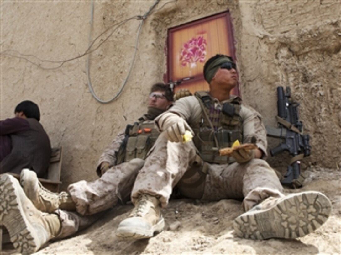 U.S. Marine Corps Cpl. Martin Kim, right, and Lance Cpl. James Brockwell take a break at the Afghan Uniform Police Outpost Mamuriyet in the Kajaki district of the Helmand province of Afghanistan, on April 1, 2013.  Kim and Brockwell are assigned Marine Corps-led Kajaki Police Mentor Team.  The mentor team visited the outpost and patrolled with the police through a nearby bazaar.  