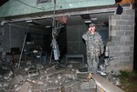 Lt. Col. James Treece, commander of the 217th Brigade Support Battalion, stands next to wreckage at Camp Shelby Joint Forces Training Center, Miss., March 3 caused by severe weather. Fourteen Soldiers with the Arkansas National Guard's 39th Infantry Brigade Combat Team were injured. Injuries were mainly limited to minor cuts and bruises, with one Soldier suffering a more severe, yet non-life-threatening injury.