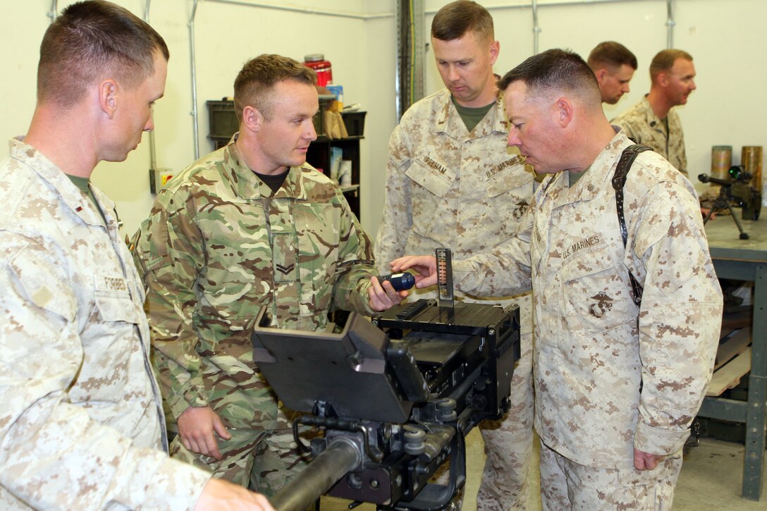 A corporal with 1 Close Support Battalion, Royal Electrical and Mechanical Engineers, shows Maj. Brian Spooner (right), the commanding officer of General Support Combat Logistics Company, Combat Logistics Regiment 2, the 40 mm high explosive grenade.