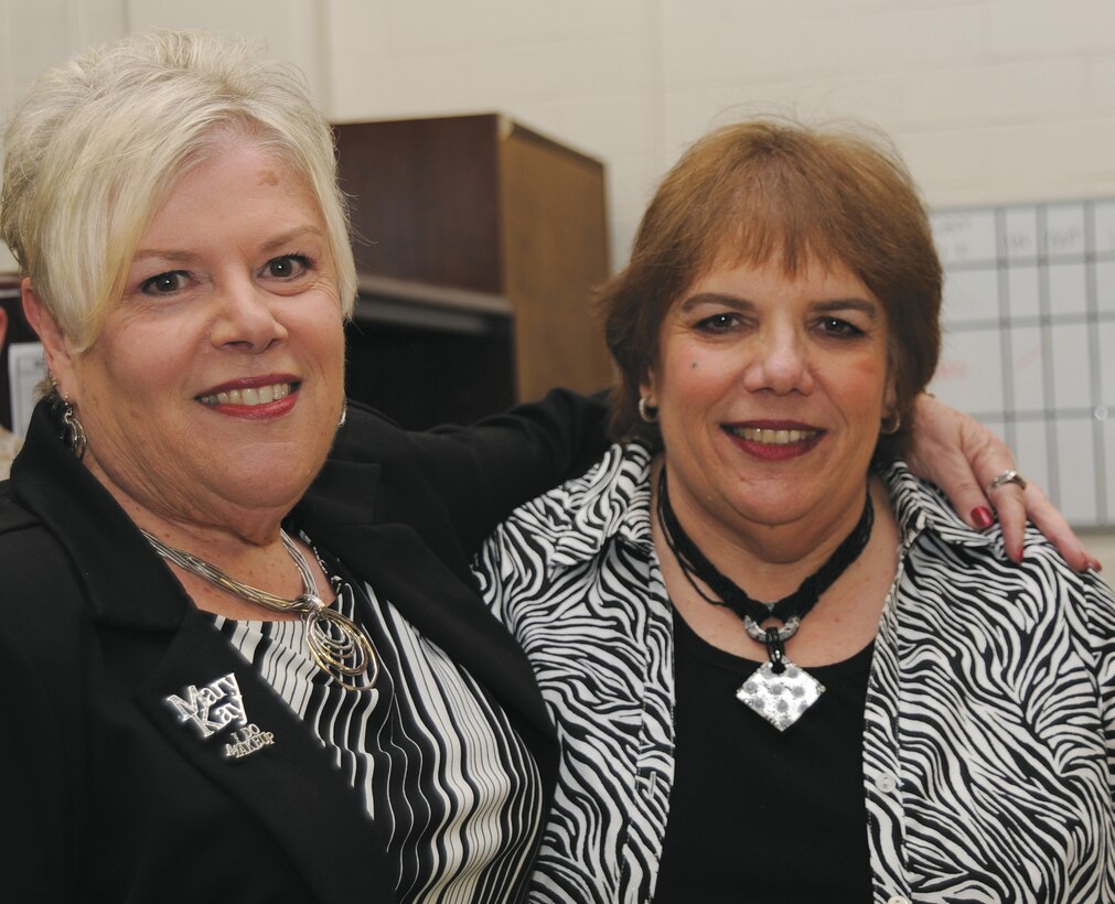 Catherine Salucci, right, receives a hug her sister, Susan. Catherine retired from civil service March 21, after more than 30 years.