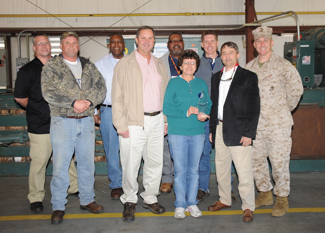 John Wilson, Southeast regional manager of Veolia Environmental Services, Valdosta, Ga., second from right, stands with Col. Don Davis, commanding officer, Marine Corps Logistics Base Albany, right. Members of the base’s Installation and Environmental Division were also present at the Base Recycling Center in Building 5511, March 25. Wilson presented Davis and the I & E team with an award to recognize the base’s recycling efforts of batteries and light bulbs. These efforts have helped the base meet the requirements of Executive Order 13514 and the Marine Corps Sustainability Plan Goals of reducing solid waste disposal by 50 percent by 2015.