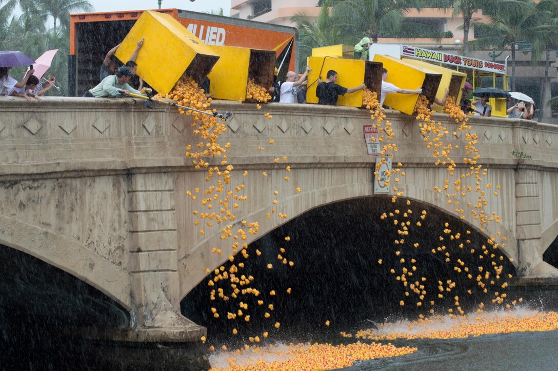 MARINE CORPS BASE HAWAII - Volunteers dump boxes of rubber duckies into the Ala Wai Canal during the 26th annual Great Hawaiian Rubber Duckie Race, March 30, 2013. The United Cerebral Palsy Association of Hawaii hosts this race every year to raise funds for its various programs. (U.S. Marine Corps photo by Kristen Wong)