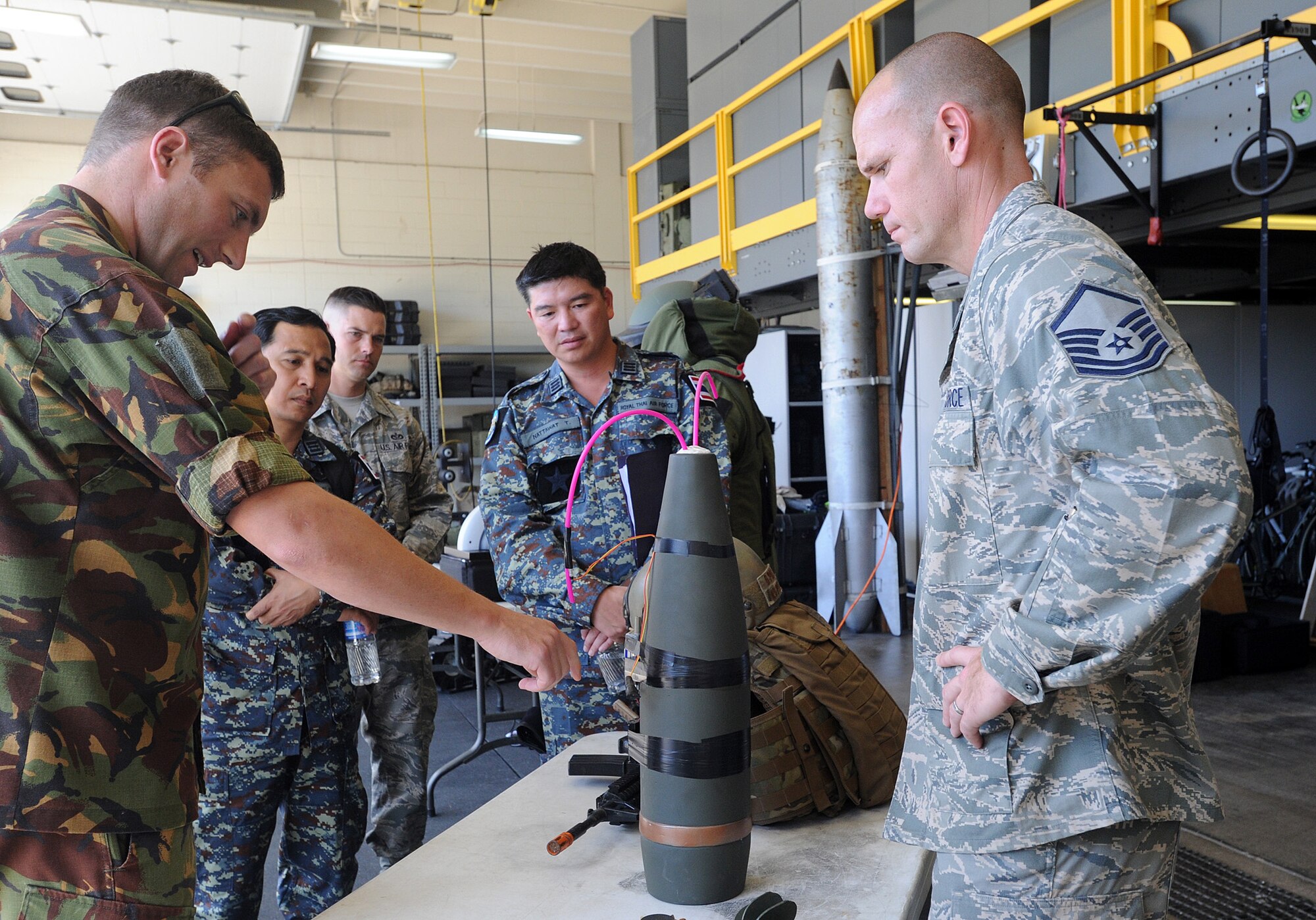 JOINT BASE PEARL HARBOR-HICKAM, Hawaii -- Master Sgt. Matthew Kredell, 647th Explosive Ordnance Disposal Flight chief, uses an inert munition to explain the EOD mission to members of the Royal Thai Air Force and Royal New Zealand Army as they participated in a Subject Matter Expert exchange as part of Pacific Unity/Defender April 3, 2013. Members of the Republic of Singapore Air Force, Japan Air Self-Defense Forces, Royal Thai Air Force, Royal New Zealand Army and Royal Cambodian Air Force participated in the exchange, part of U.S. Pacific Command’s Theater Security Cooperation Program, co-hosted by senior civil engineering and security forces personnel from Pacific Air Forces. (U.S. Air Force photo/Tech. Sgt. LuCelia Ball)