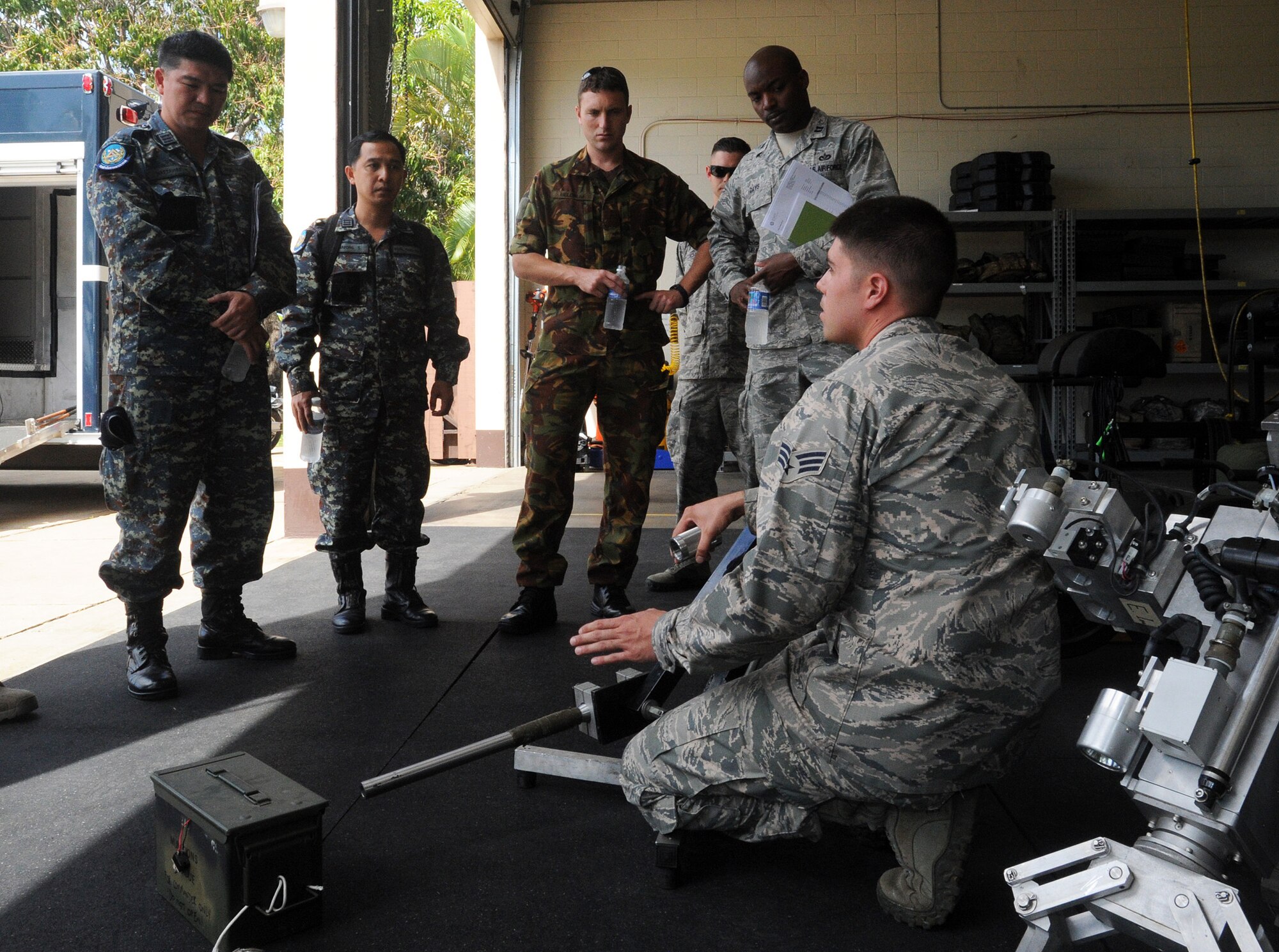 JOINT BASE PEARL HARBOR-HICKAM, Hawaii -- Senior Airman Vincent Irr, 647th Explosive Ordnance Disposal Flight technician, explains the functions of a percussion-actuated neutralizer to members of the Royal Thai Air Force and Royal New Zealand Army as they participated in a Subject Matter Expert exchange as part of Pacific Unity/Defender April 3, 2013. Members of the Republic of Singapore Air Force, Japan Air Self-Defense Forces, Royal Thai Air Force, Royal New Zealand Army and Royal Cambodian Air Force participated in the exchange, part of U.S. Pacific Command’s Theater Security Cooperation Program, co-hosted by senior civil engineer and security forces personnel from Pacific Air Forces. (U.S. Air Force photo/Tech. Sgt. LuCelia Ball)