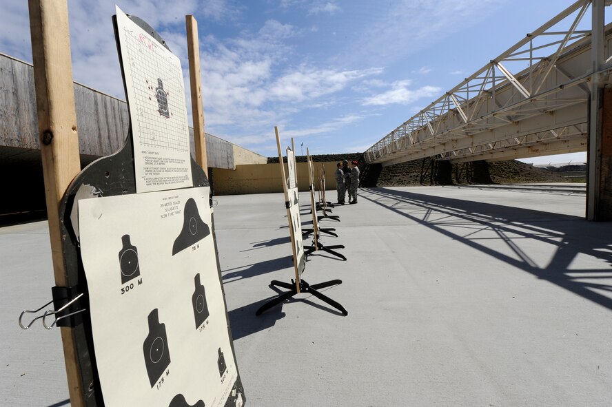 Combat Arms Training and Maintenance instructors provide assistance to a shooter who needs help with making accurate shots at Fairchild Air Force Base, Wash., March 25, 2013. Instructors will stay after the class to help anyone who needs additional training. (U.S. Air Force photo by Airman 1st Class Ryan Zeski)