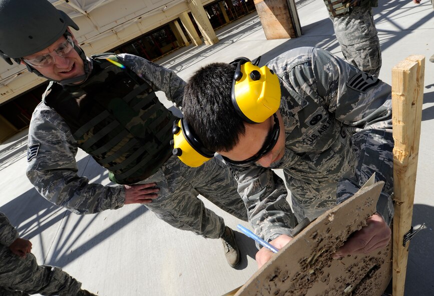 Staff Sgt. Jason Garcia, 92nd Security Forces Squadron combat arms instructor, marks the target for hits at Fairchild Air Force Base, Wash., March 25, 2013. After firing practice rounds shooters are required to pass a qualification test. (U.S. Air Force photo by Airman 1st Class Ryan Zeski)
