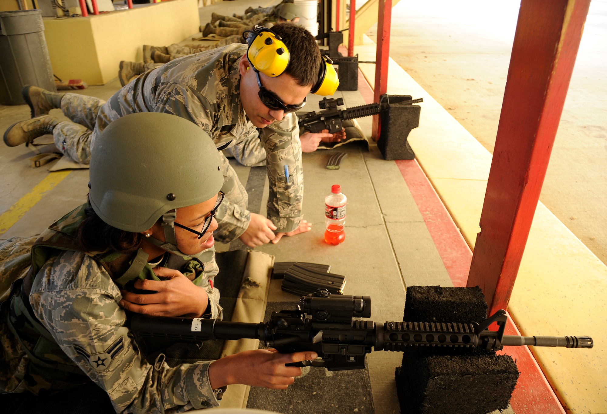 Staff Sgt. Jason Garcia, 92nd Security Forces Squadron combat arms instructor, provides instructions to Airman 1st Class LeDrea Taylor, 92nd Logistics Readiness Squadron air refueling squadron supply, at the shooting range at Fairchild Air Force Base, Wash., March 25, 2013. There are seven instructors who work at Combat Arms Training and Maintenance, making it possible to train more than 2,500 Airman each year. (U.S. Air Force photo by Airman 1st Class Ryan ZeskI)
