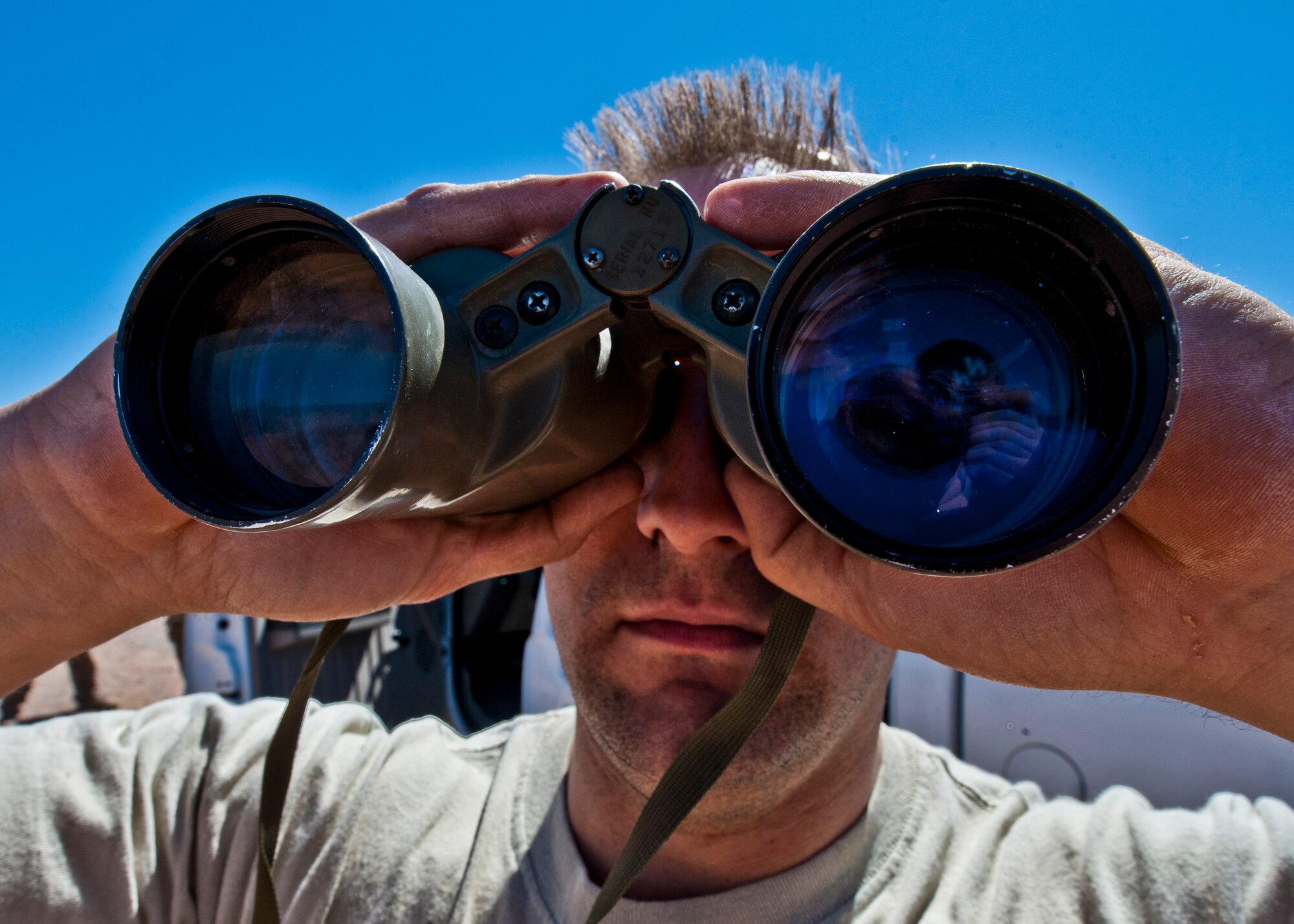 Tech. Sgt. Daniel Roman, 49th Operations Support Squadron survival, evasion, resistance and escape specialist, uses binoculars to estimate the approximate distance of an object in Orogrande, N.M., March 13. As a SERE specialist at Holloman Air Force Base, N.M., Roman is charged with teaching aircrew members many essential lessons about survival. (U.S. Air Force photo by Airman 1st Class Daniel E. Liddicoet/Released)

