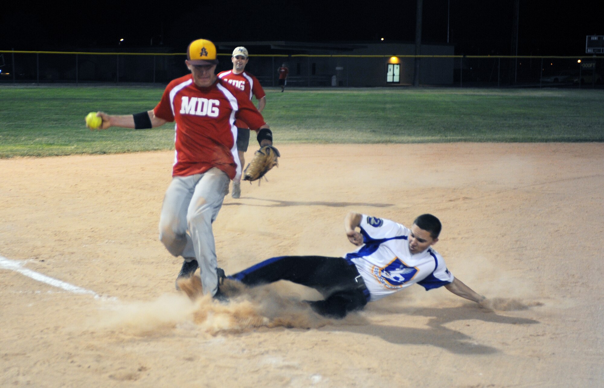 Alex Balok, 56th Medical Group, steps on third base as Dustin Barnes, 56th Security Forces Squadron, slides during the fifth inning of an intramural softball game played Oct. 10 2012, at a Luke Air Force Base Bryant Fitness Center softball field. The umpire called Barnes safe. (U.S. Air Force photo/Airman 1st Class David Owsianka