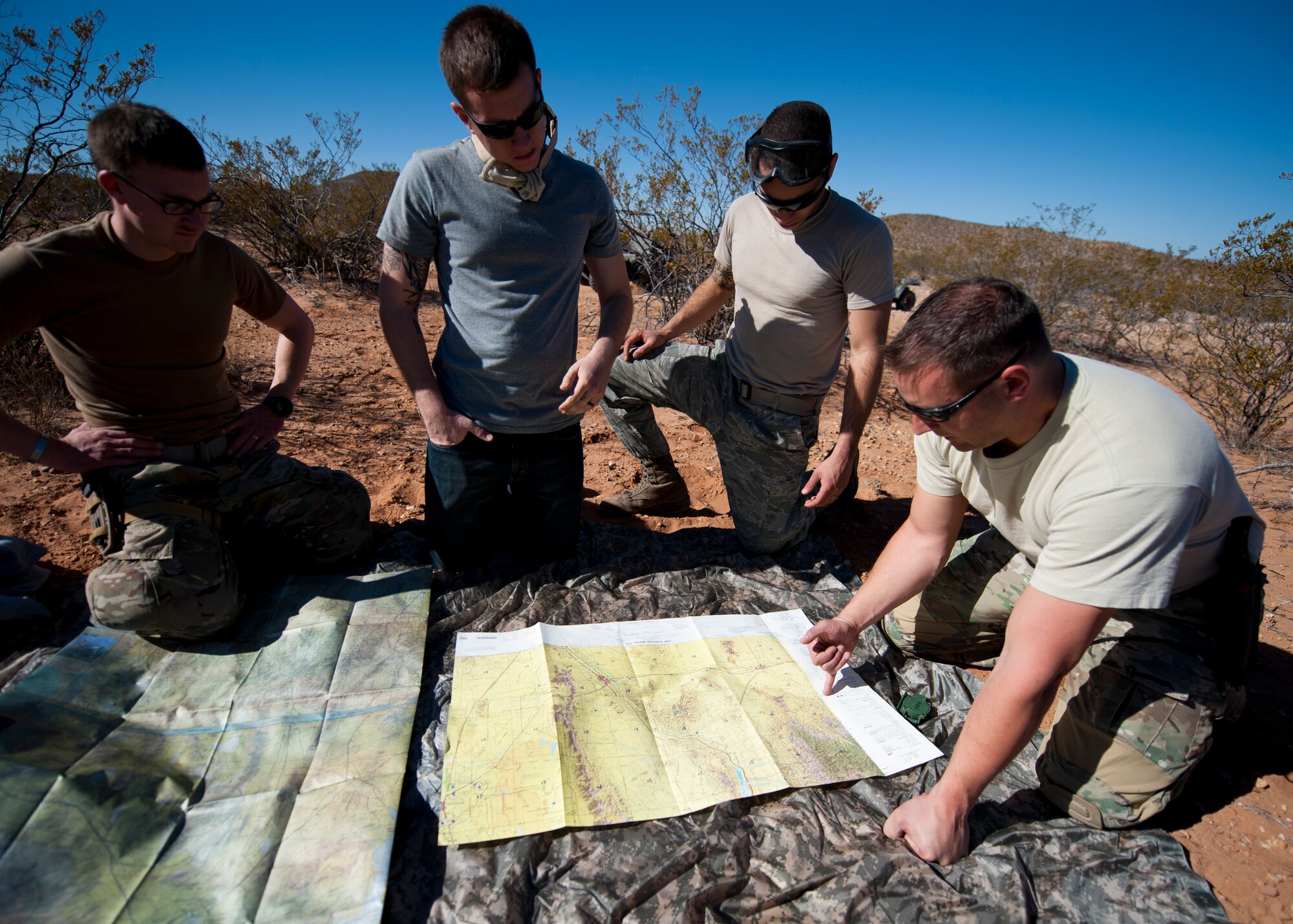 Tech. Sgt. Daniel Roman, 49th Operations Support Squadron survival, evasion, resistance and escape specialist, instructs a group of students on the basics of land navigation in Orogrande, N.M., March 13.  Roman emphasized the importance of being able to find your position and correctly communicate it to rescue forces. As a SERE specialist at Holloman Air Force Base, N.M., Roman is charged with teaching aircrew members many essential lessons about survival. (U.S. Air Force photo by Airman 1st Class Daniel E. Liddicoet/Released)