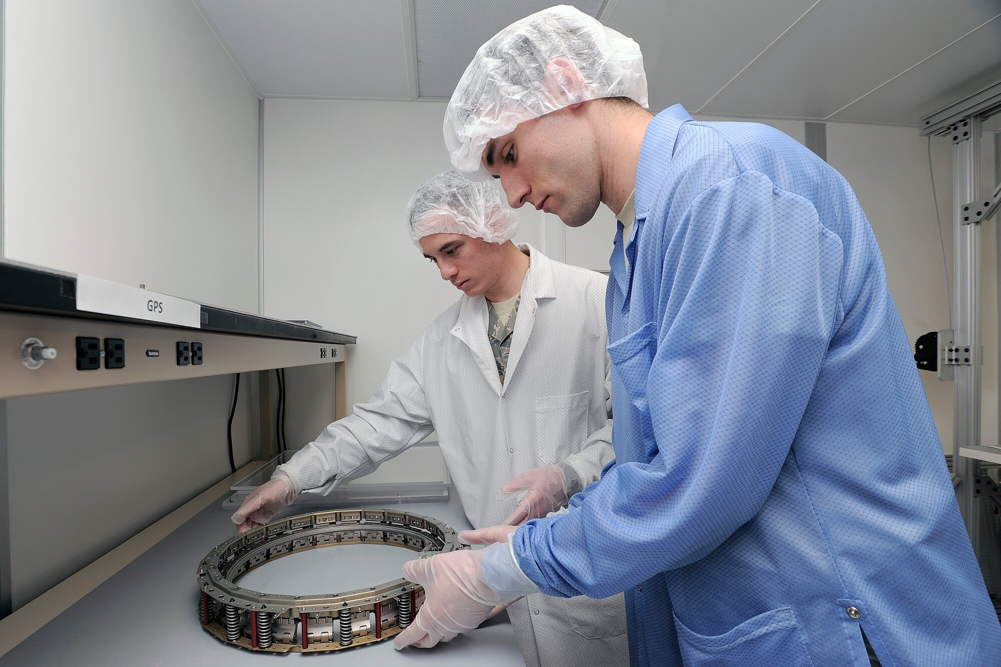 Cadets 1st Class Andru Vandiver (front) and Drew Hilton (rear) works on a component for Falcon SAT-6 Monday, April 1st. (U.S. Air Force Photo/Sarah Chambers)