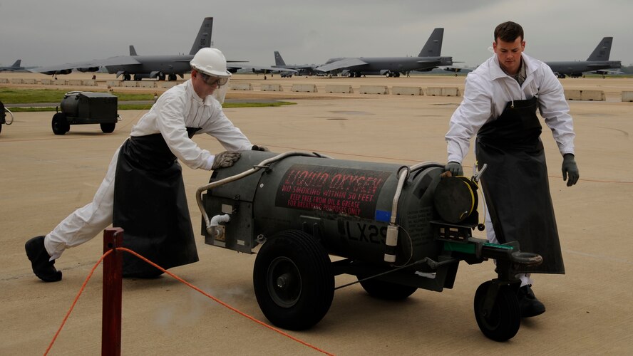 Staff Sgt. Mitchell Newman and Senior Airman Daniel Bohn,  2nd Logistics Readiness Squadron Fuels Facilities, push a filled liquid oxygen cart on Barksdale Air Force Base, La., April 4, 2013. The fuels facilities section is in charge of the reception, storage and distribution on fuel for Barksdale's fleet of B-52H Stratofortress bombers. (U.S. Air Force photo/Airman 1st Class Andrew Moua)