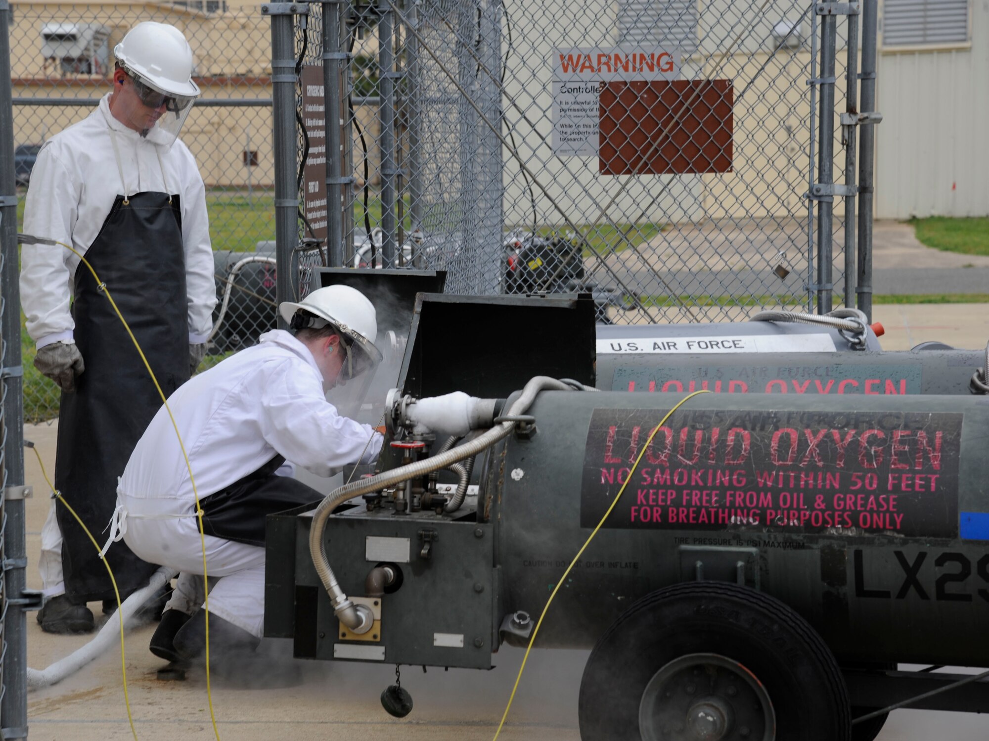 Senior Airman Daniel Bohn, 2nd Logistics Readiness Squadron Fuels Facilities, takes a sample of liquid oxygen as Staff Sgt. Mitchell Newman, 2 LRS Fuels Facilities, observes on Barksdale Air Force Base, La., April 4, 2013. The Airmen drew samples of liquid oxygen to test for particulates and odor. If either is found, the Airmen must determine what is causing the contamination and restore the oxygen to a useable state. (U.S. Air Force photo/Airman 1st Class Andrew Moua)