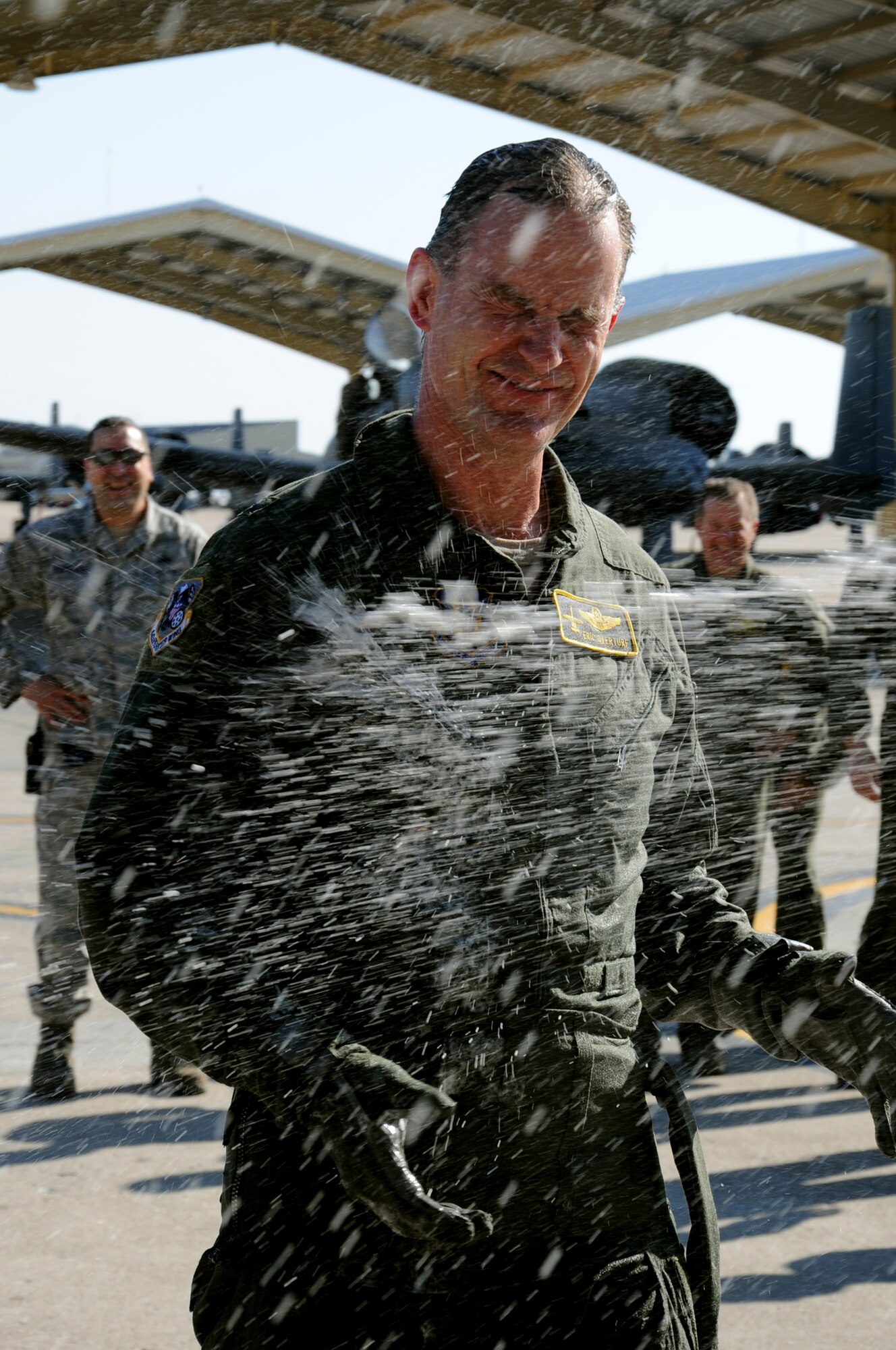 Brig. Gen. Eric Overturf, 442nd Fighter Wing commander, is sprayed with water from a flightline hose by his family after flying his “fini” flight with the 442nd FW, April 4, 2013. The “fini” flight is a tradition commemorating the final flight of a pilot. (U.S. Air force photo/Staff Sgt. Lauren Padden)