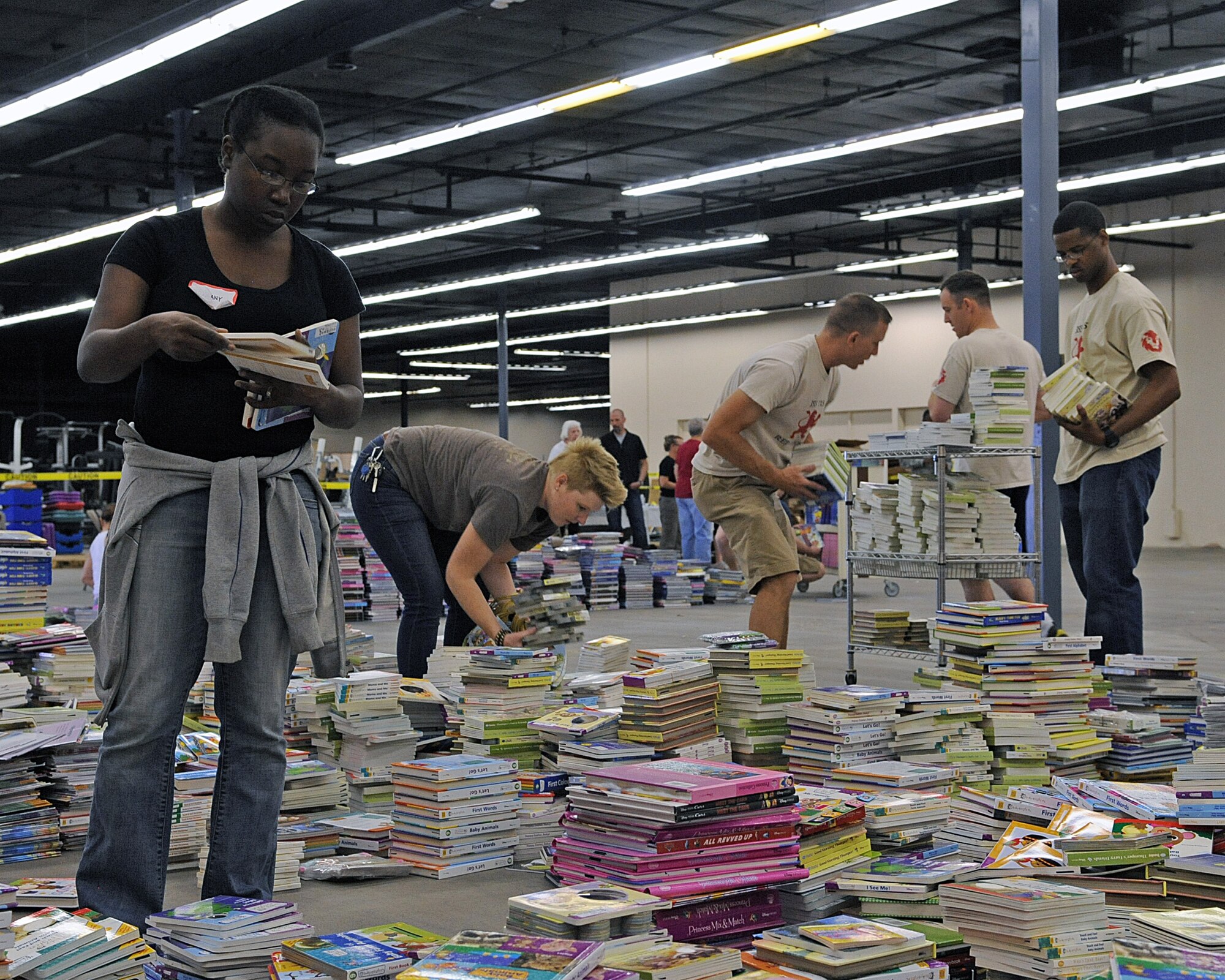 U.S. Air Force Airmen and Tucson citizens sort books at the Bookman's warehouse for First Book Tucson in Tucson, Ariz., April 2, 2013. First Book Tucson's mission is to give children from low-income families in Tucson the opportunity to read their very own books. (U.S. Air Force photo by Airman 1st Class Christine Griffiths/Released)