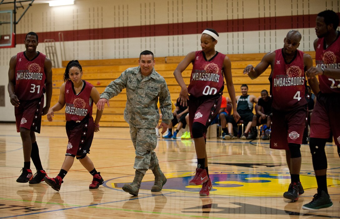 Tech. Sgt. James Paz, 28th Force Support Squadron Bellamy Fitness Center NCO in-charge, struts with the Harlem Ambassadors during the basketball game at Bellamy Fitness Center on Ellsworth Air Force Base, S.D., March 26, 2013. At the start of the third quarter, the Harlem Ambassadors invited Paz to center court to be recognized for his efforts in making the event possible for Ellsworth Airmen and their families. (U.S. Air Force photo by Tech. Sgt. Jerry Fleshman/Released)