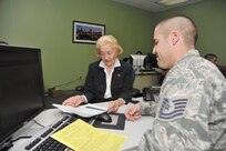 Dr. Tricia Hall goes over her 2012 income tax return with Tech. Sgt. Joseph Duffy,  volunteer preparer at the Joint Base San Antonio-Lackland Tax Center. Hall said using the center for her income tax preparation and filing has been a “wonderful experience,” which she attributed to the volunteers, preparation fee savings and location convenience. (Photo by Alan Boedeker)