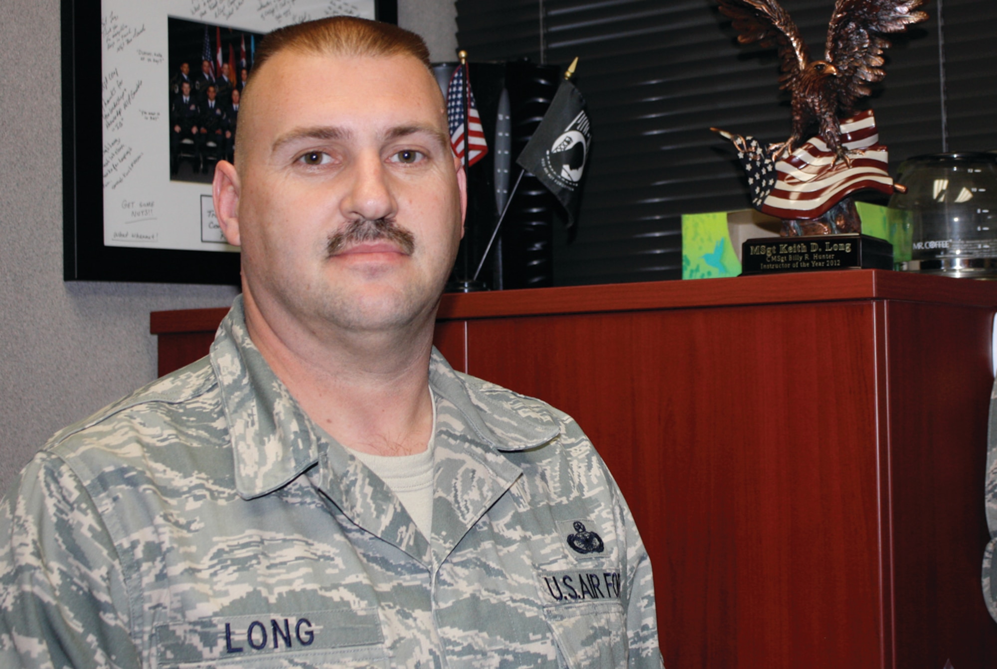 Accepting the Chief Master Sgt. Billy R. Hunter SNCOA Instructor of the Year Award reaffirmed Master Sgt. Keith Long's decision to leave security forces and make a difference through his flight room. (U.S. Air Force photo by Rebecca Burylo)
