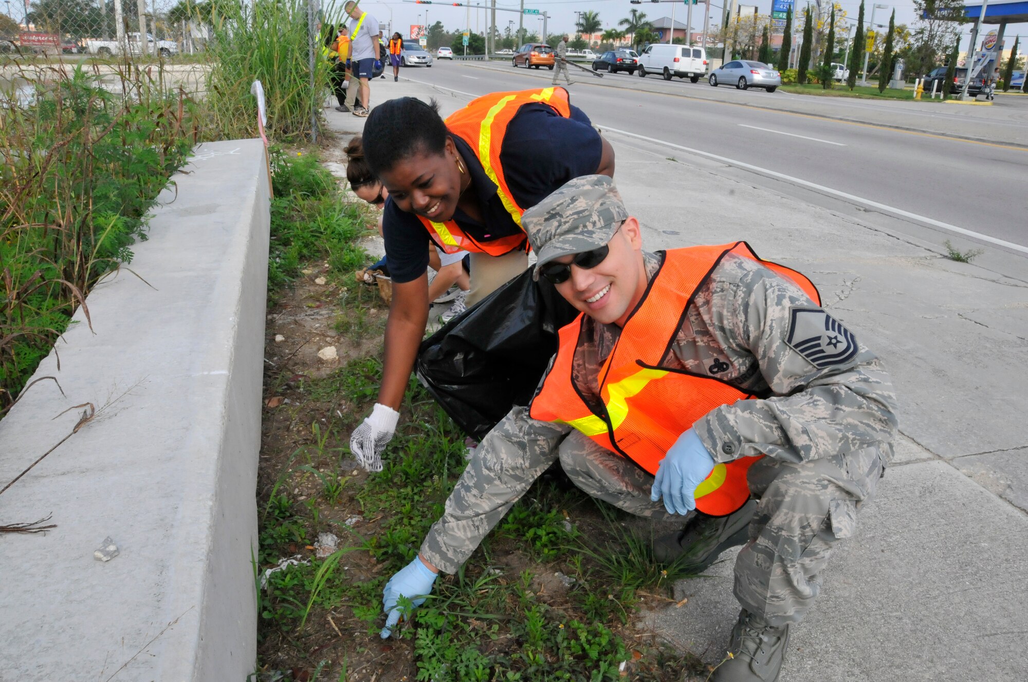 Master Sgt. Desmond Ojeda, Detachment 93, 495th Fighter Group and Marie Douyon, Homestead Job Corps Center pick up trash along Southwest 288th St., in Homestead, Fla., on April 3.  Fifty Airmen, Coast Guard and civilian employees from Homestead Air Reserve Base teamed up with students from HJCC to pick up trash and spend some time with each other as part of the Adopt-A-Road program.  (U.S. Air Force photo/Senior Airman Nicholas Caceras)
