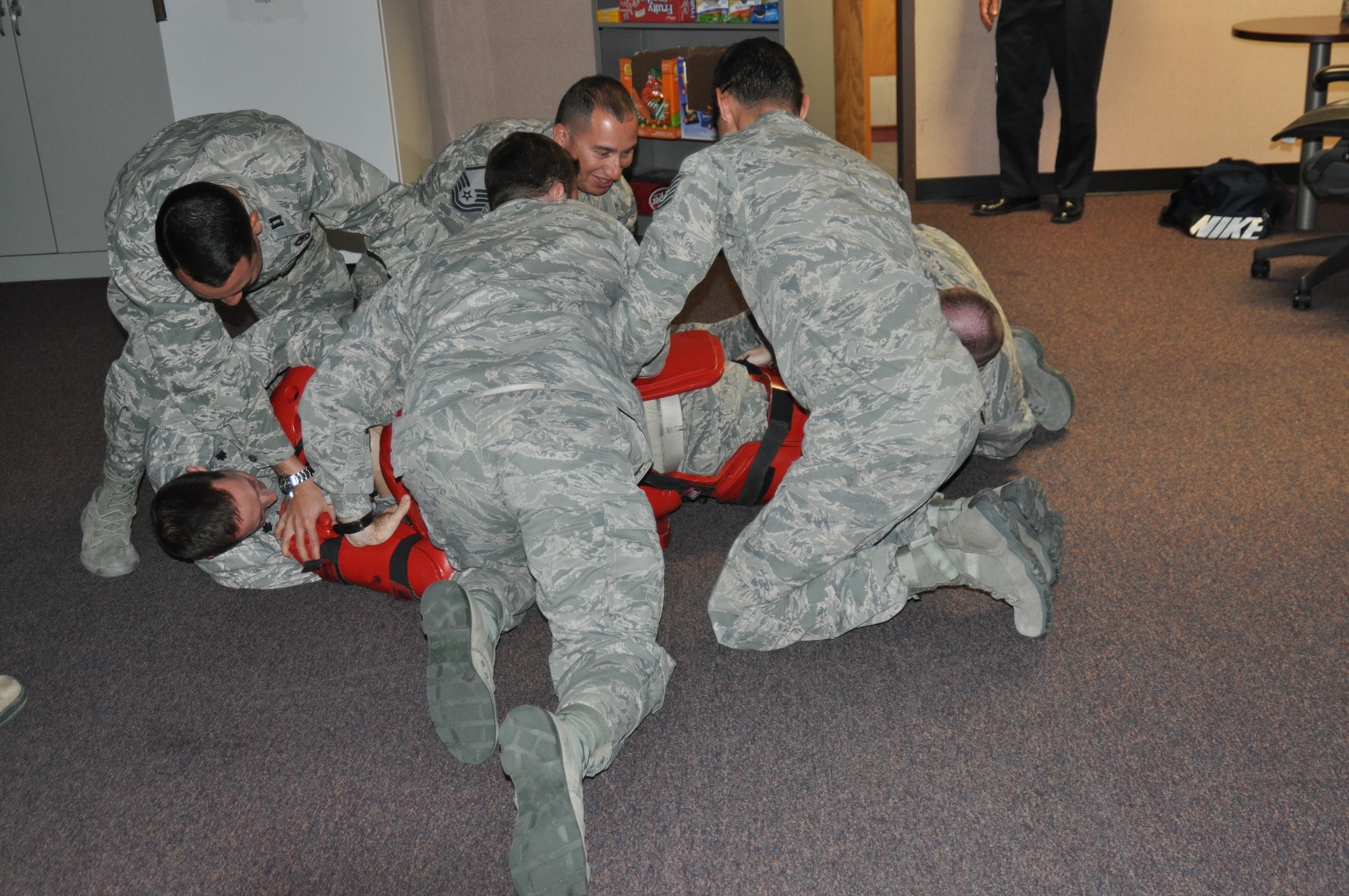 Members of the 12th Air Force (Air Forces Southern) A4/7 directorate tackle and subdue the active-shooter threat, Master Sgt. Paul Azevedo, 12th AF (AFSOUTH) A4/7, during an exercise at Davis-Monthan AFB, Ariz., April 4. (USAF photo by Master Sgt. Kelly Ogden/Released). 