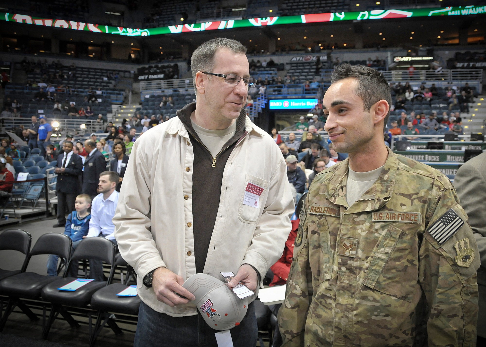 Senior Airman Jefferson Harkleroad, an Air Force electrician serving in the Civil Engineering Squadron at Milwaukee’s 128th Air Refueling Wing, stands courtside at the BMO Harris Bradley Center in Milwaukee with his father, Senior Master Sgt. Phil Harkleroad, Wed., April 3, 2013.
Harkleroad, who had recently returned from a deployment to Afghanistan, was honored by the Milwaukee Bucks and Waukesha Metal as part of their “Hardwood Homecoming” program and presented the official game ball the team captains prior to the start of the game.  (Air National Guard Photo by 1st Lt. Nathan Wallin / Released)