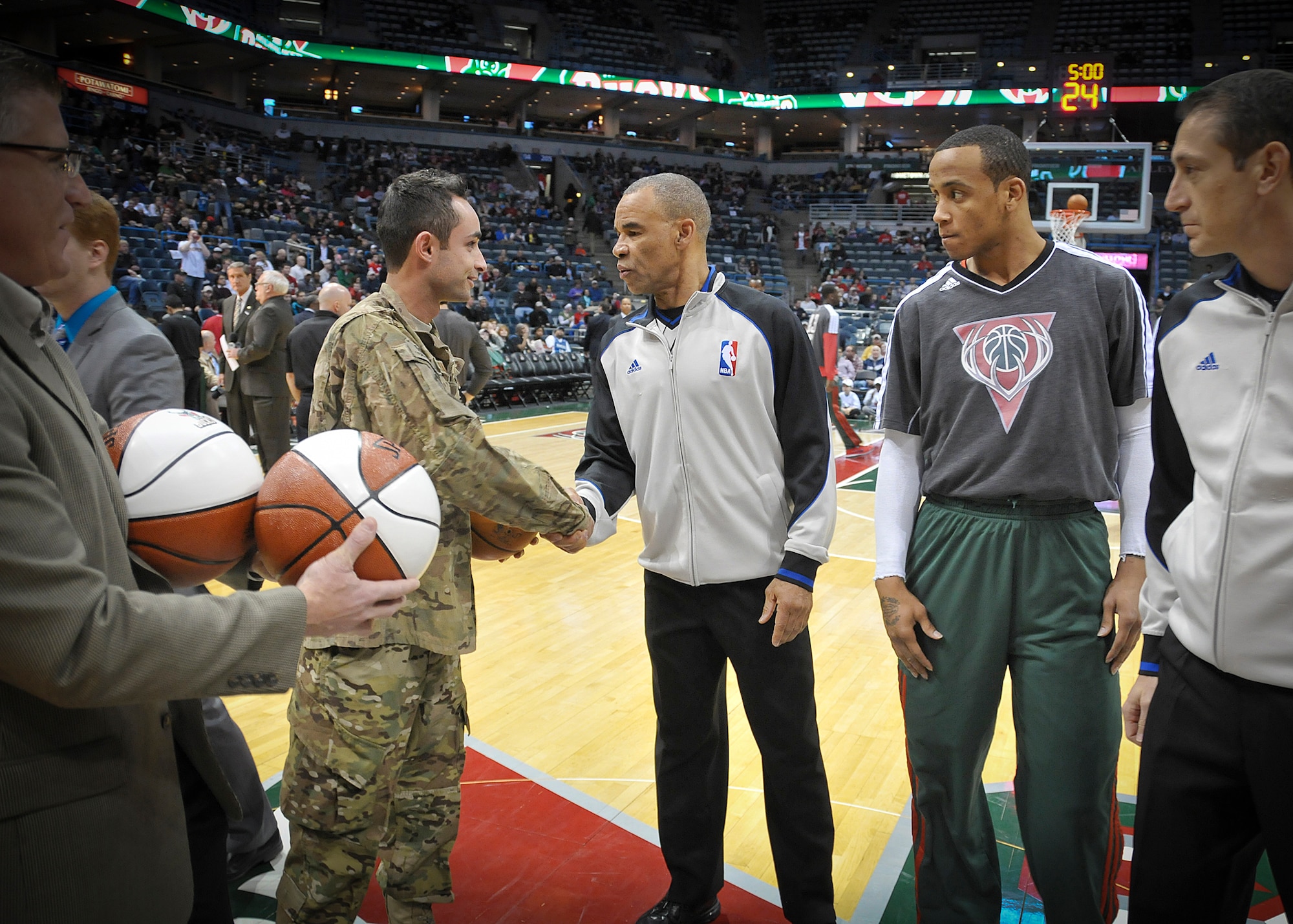 Senior Airman Jefferson Harkleroad, an Air Force electrician serving in the Civil Engineering Squadron at Milwaukee’s 128th Air Refueling Wing, shakes hands with an NBA referee at center court of the BMO Harris Bradley Center in Milwaukee Wed., April 3, 2013. 
Harkleroad, who had recently returned from a deployment to Afghanistan, was recognized prior to the Bucks game against the Minnesota Timberwolves as part of the “Hardwood Homecoming” program. (Air National Guard Photo by 1st Lt. Nathan Wallin / Released)