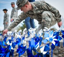 Capt. Steven Hyer plants a pinwheel near the main gate in recognition of Child Abuse Prevention Month April 1, 2013, at Mountain Home Air Force Base, Idaho. Stressful or traumatic childhood experiences have been linked to social, emotional or cognitive impairments in adults. Hyer is assigned to the 366th Medical Operations Squadron. (U.S. Air Force photo/Tech. Sgt. Samuel Morse)