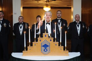 Retired Chief Master Sgt. of the Air Force Robert Gaylor lights the chief’s candle during the Chief Master Sergeant Recognition Ceremony March 9, 2013, at Royal Air Force Lakenheath, England. The rank of chief master sergeant represents the top one percent of the enlisted force. (U.S. Air Force photo/Airman 1st Class Dana J. Butler)