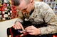 U.S. Marine Corps Cpl. Landon Beaty, Air Force Mortuary Affairs Operations, measures the space between a shooting badge and the ribbons of a uniform being prepared for a fallen Marine April 2, 2013, on Dover Air Force Base, Del. Marine Corps liaisons spend up to three hours perfecting one uniform, removing loose threads, aligning the anchor buttons and ensuring decorations are in the proper order. (U.S. Air Force photo/David Tucker)