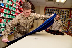 U.S. Marine Corps Staff Sgt. John Clements (left) and Cpl. Landon Beaty, Air Force Mortuary Affairs Operations, assembles a dress blues uniform for a fallen Marine April 2, 2013, on Dover Air Force Base, Del. Clements and Beaty are Marine Corps liaisons, who coordinate an array of details associated with the return of fallen Marines.  (U.S. Air Force photo/David Tucker)