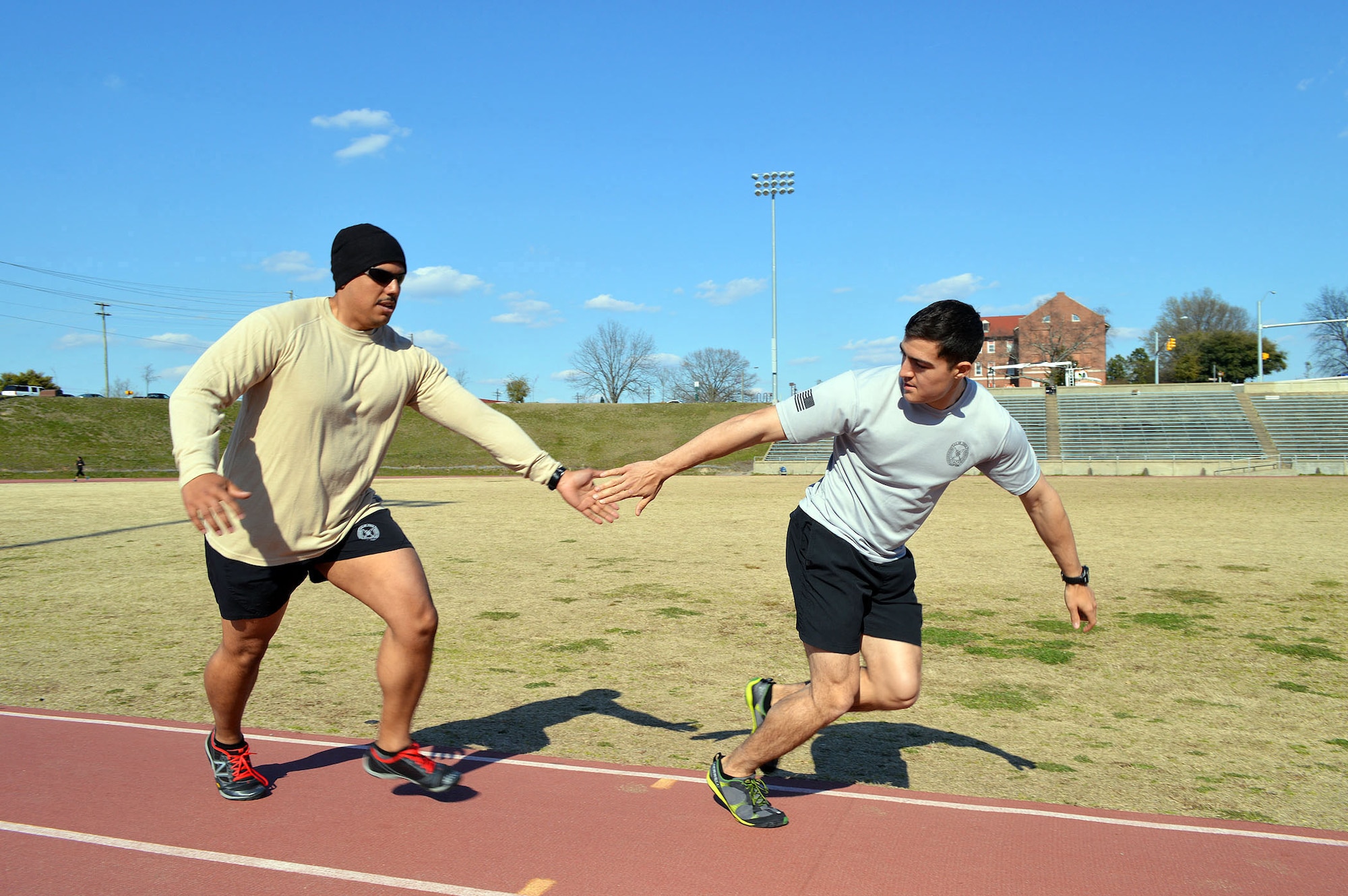 Airman 1st Class Giovan Vitale, left, tags Airman 1st Class Matthew Taylor after completing his run at the Hedrick Stadium track during the second annual worldwide TACP 24-hour Challenge Run, March 28-29.  Both are TACPs assigned to the 14th Air Support Operations Squadron.  The event is held to honor and raise funds for fallen TACP brothers in arms and their families.  (U.S. Air Force photo by Marvin Krause/Released)